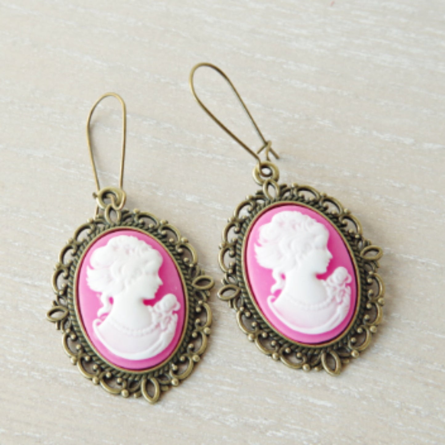 Texte pour la photo :
Boucles d’oreilles camée rose avec silhouette de jeune femme, style vintage raffiné sur crochets anciens, présentées sur fond neutre pour souligner leur élégance intemporelle.