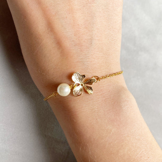 Collier orchidée dorée – Fleur délicate et perle ivoire en verre sur chaîne plaquée or d’ajustement