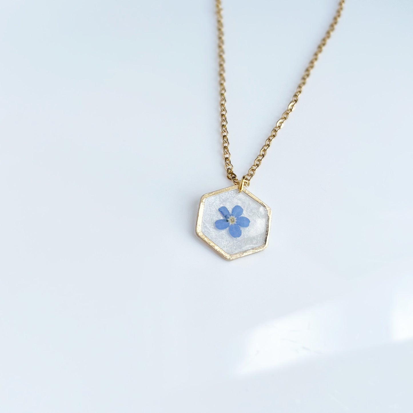 Small blue forget-me-not flower in resin necklace for women  flower in hexagonal gold pendants Minimalist jewelry gifts for her